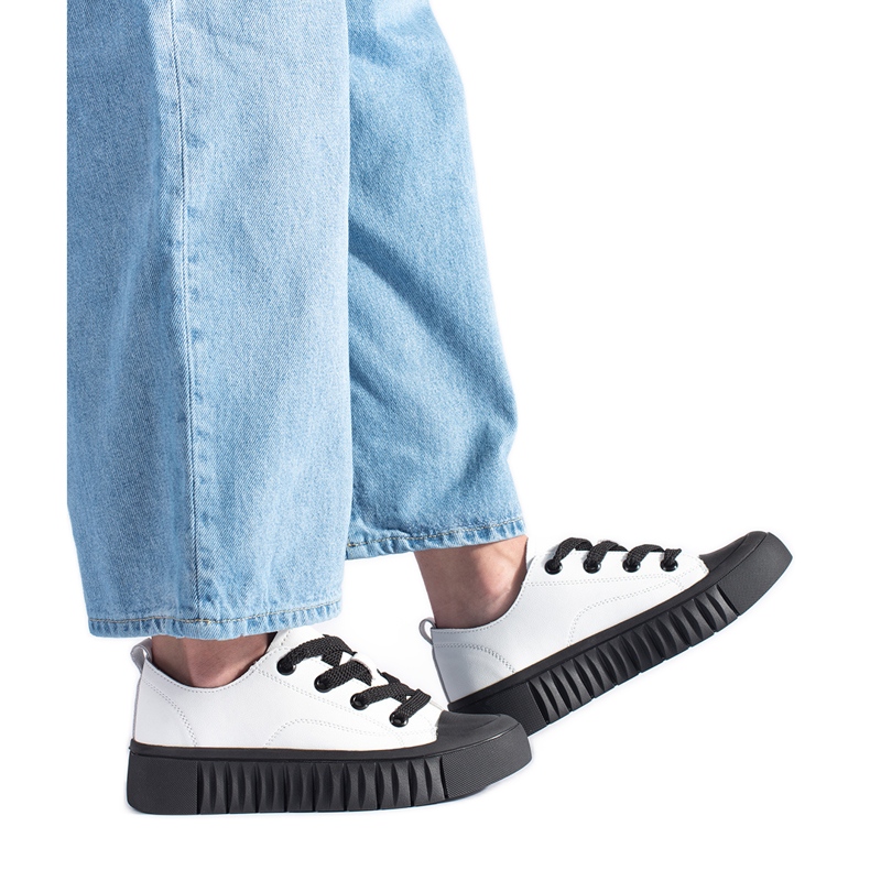 Bílé a černé nízké tenisky vyrobené z přírodní kůže bílý